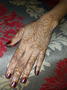 a woman's hand with henna tattoos on it