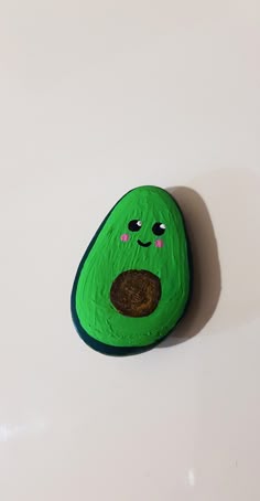 a green rock with a face painted on it