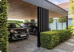 two cars are parked in the driveway under a covered car port with trees and bushes