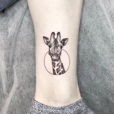a giraffe's head with a circle around it on the ankle tattoo