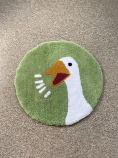 a green rug with a white duck on it's face and an orange beak