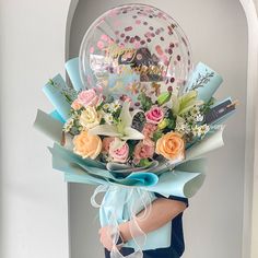 a person holding a bouquet of flowers and balloons