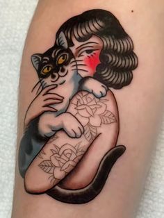 a woman with a cat tattoo on her arm is holding it's paw up
