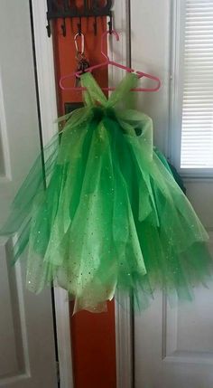 a green tutu skirt hanging from a door