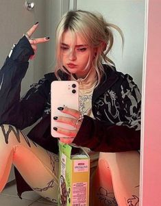 a woman sitting on the floor with her cell phone