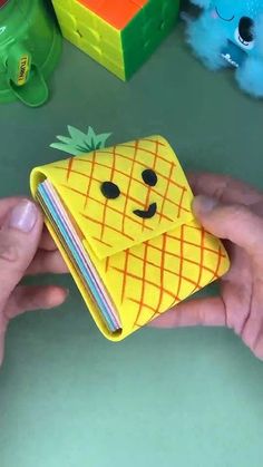 a person holding a small wallet with a pineapple on it