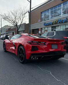 a red sports car parked in front of a store