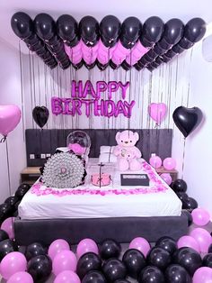 a birthday party with balloons and teddy bears on the bed in front of the wall