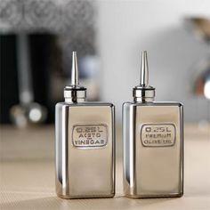 two silver lighters sitting on top of a wooden table