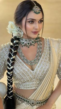 a woman in a white sari with braids and jewelry