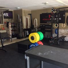a gym with several different colored discs on the floor and equipment hanging from the ceiling