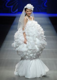 a woman in a wedding dress on the runway