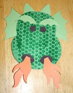a paper cut out of a green frog