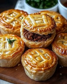 several pies with meat in the middle on a cutting board