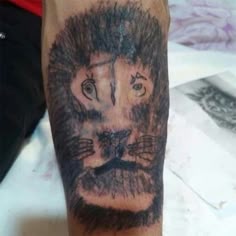 a man with a lion tattoo on his arm is shown in black and grey ink