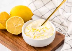 a bowl of yogurt next to lemons on a cutting board