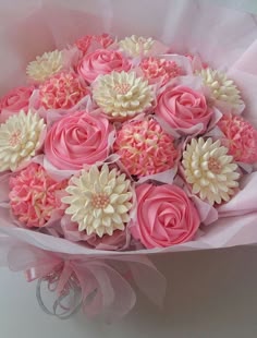 a bouquet of pink and white cupcakes with flowers