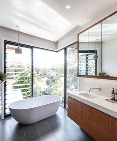 a bathroom with a large white bathtub next to a sink