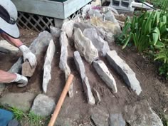 a man is working on some rocks in the yard