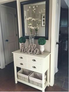 there is a mirror and some vases on the table in front of the door