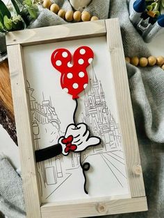a wooden frame with a drawing of a mickey mouse holding a red balloon in the shape of a heart