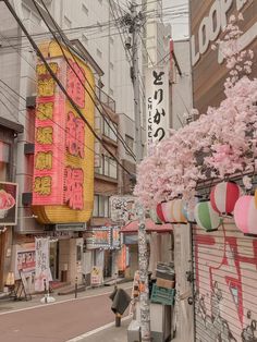 a city street lined with tall buildings covered in pink flowers