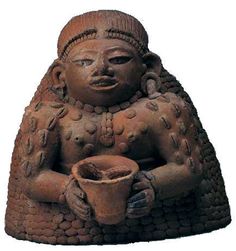 a clay statue holding a cup and saucer