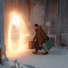 a woman carrying two suitcases in front of a firework display at the entrance to a building