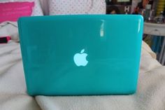 an apple laptop sitting on top of a bed