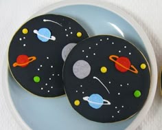 three decorated cookies sitting on top of a blue plate