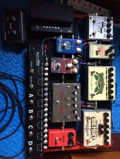 an assortment of pedals and other electronic devices sitting on a blue surface next to each other