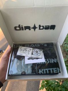 someone holding up a box with stickers on it that says dirt bar in the bottom right corner