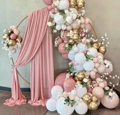 a balloon arch with balloons and flowers on it