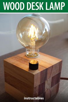 a light bulb sitting on top of a wooden block with the words how to make a wood desk lamp