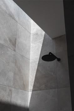 a shower head in the corner of a room with tile walls and flooring on it