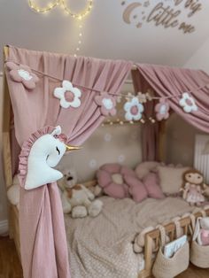 a child's bedroom with pink curtains and stuffed animals