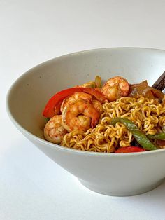 a white bowl filled with noodles and shrimp