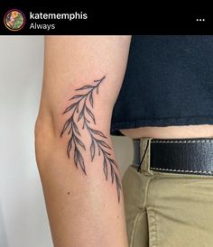 a woman's arm with a tattoo on it that has leaves growing out of it