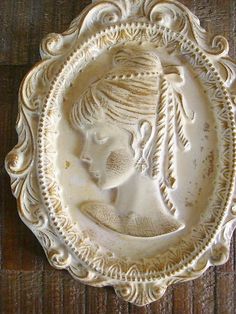 a white ceramic plate with a woman's face on the front and side of it