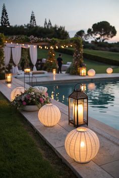 lanterns lit up near a pool at night