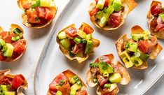 small appetizers are arranged on a white platter, ready to be eaten