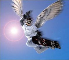 a man flying through the air while riding a snowboard with wings on his back