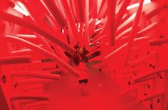 a red room filled with lots of white pipes and wires on the ceiling, all connected to each other