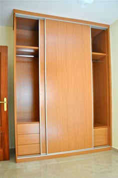 an empty closet with wooden doors and drawers