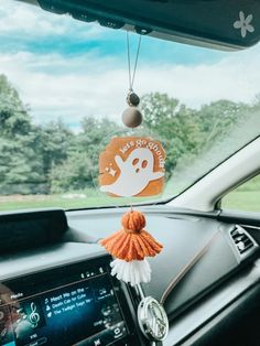 a car dashboard with an orange and white keychain hanging from the dash board