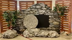 a stone fireplace surrounded by rocks and plants