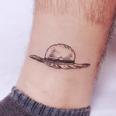 a small hat tattoo on the ankle