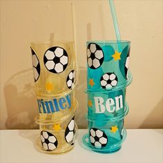 three personalized tumblers with soccer balls and stars on them, one has a straw in it