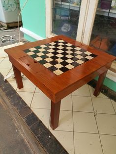 a wooden table with a checkerboard pattern on it in front of a store
