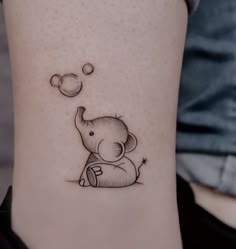 a small elephant tattoo on the ankle with bubbles coming out of it's trunk